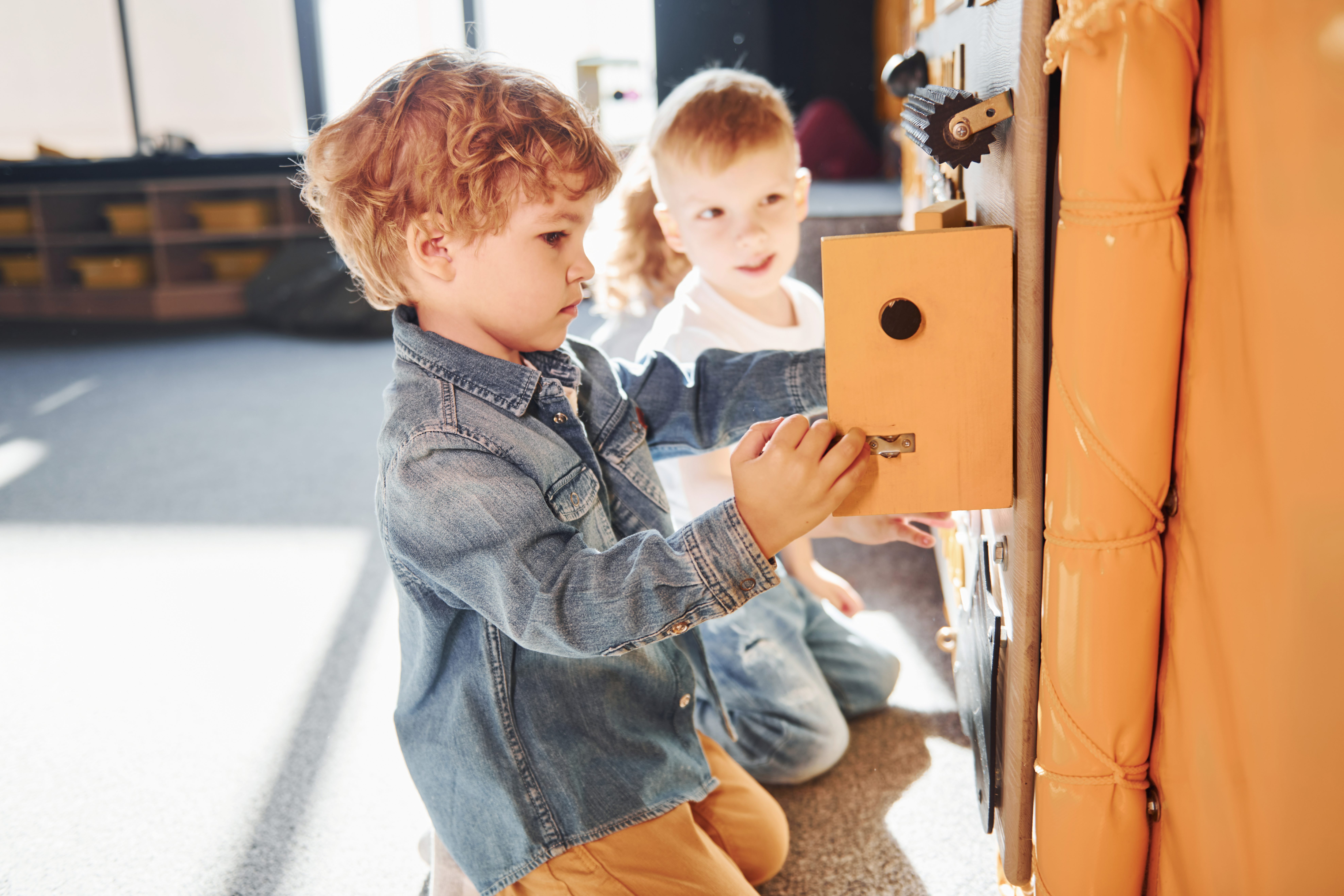 Children have fun in playroom near the wall